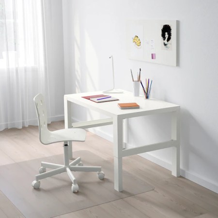 A small white desk . It’s adjustable at 3 different heights and has practical cable boxes for power strips for your electronic devices.